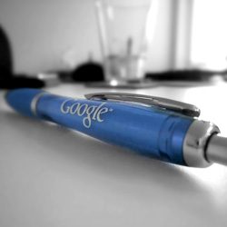 Ein blau eingefärbter Kugelschreiber mit dem Google-Logo